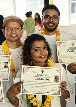 Smiling students holding their yoga teacher training certificates